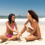 girls sitting on a beach